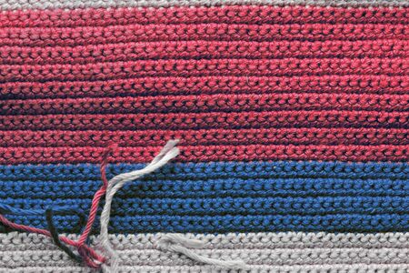 Crochet texture close-up of blue, red and beige threads, top view. Hand made concept. Abstract background with copy spaceの写真素材
