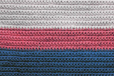 Crochet texture close-up of blue, red and beige threads, top view. Hand made concept. Abstract background with copy spaceの写真素材