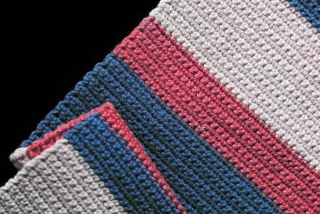 Crochet texture close-up of blue, red and beige threads, top view. Hand made concept. Abstract background with copy spaceの写真素材