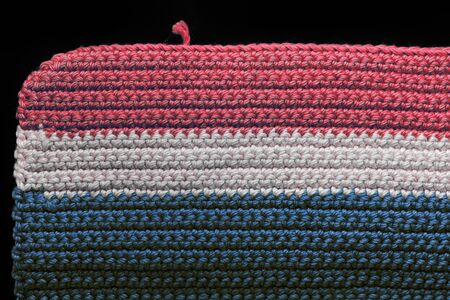 Crochet texture close-up of blue, red and beige threads, top view. Hand made concept. Abstract background with copy spaceの写真素材