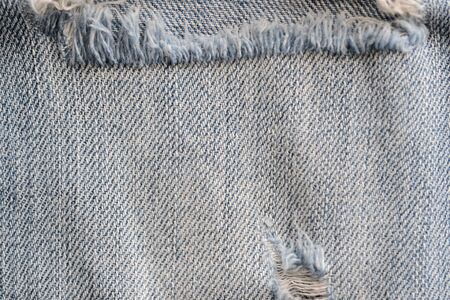 Old torn blue jeans texture close up, top view. Denim background