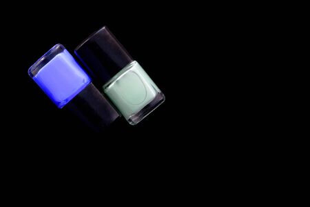 Nail polish bottles on black background, top view. With copy space. Manicure art cosmetic toolsの写真素材