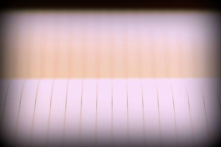 Open notebook with lined pages on a dark background. Retro style toned, vignetting