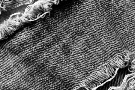 Old jeans texture close-up, top view. Monochrome denim background