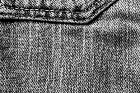 Old jeans texture close-up, top view. Monochrome denim background