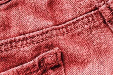 Old jeans texture close up, top view. Denim background, red color tonedの写真素材