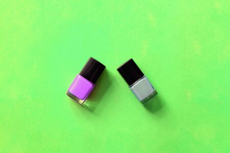 Nail polish bottles on a bright green background close-up. Manicure art cosmetic, nail art. Top view, copy spaceの写真素材