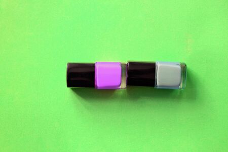 Nail polish bottles on a bright green background close-up. Manicure art cosmetic, nail art. Top view, copy spaceの写真素材