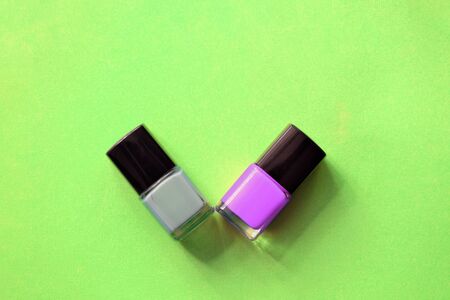 Nail polish bottles on a bright green background close-up. Manicure art cosmetic, nail art. Top view, copy spaceの写真素材