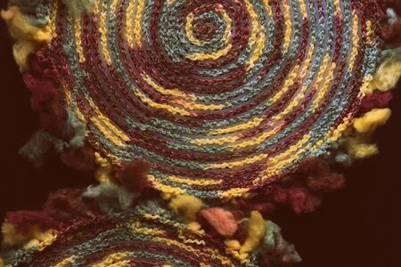 Fluffy multi-colored yarn crocheted on a round plastic canvas close-up. Two parts for the handmade bag. Retro style toned. Top viewの写真素材
