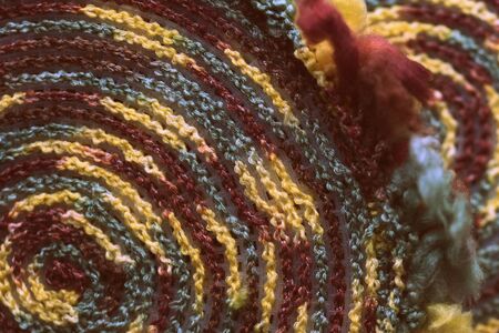 Fluffy multi-colored yarn crocheted on a round plastic canvas close-up. Two parts for the handmade bag. Retro style toned. Top viewの写真素材