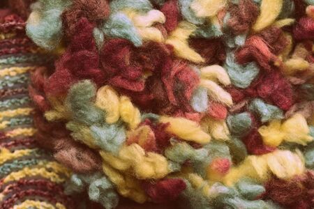 Fluffy multi-colored yarn crocheted on a round plastic canvas close-up. Two parts for the handmade bag. Retro style toned. Top viewの写真素材