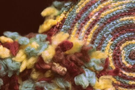 Fluffy multi-colored yarn crocheted on a round plastic canvas close-up. Two parts for the handmade bag. Retro style toned. Top viewの写真素材