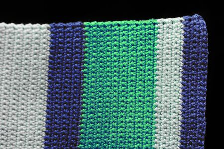 Fragment of a crocheted fabric close-up. Top view, copy space. Handmade backgroundの写真素材