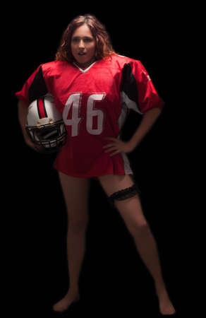 Sexy American football player holding helmet on a black background の写真素材