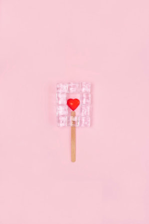 Ice cream with ice cubeas and red hearth in the middle on the pink background.Valentines day...