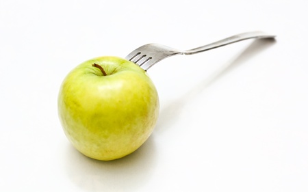 A fork attached to an apple isolated on white backgroundの写真素材