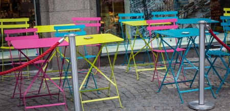 Some colored chairs and table outside a cafeの写真素材