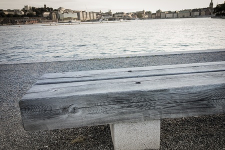 A wooden bench near the water in Stockholmの写真素材