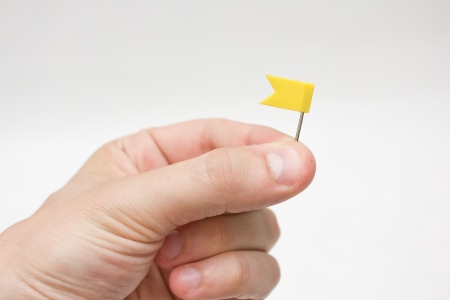 Hand holding a coloured mini flagの写真素材