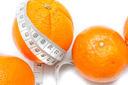Measuring tape around a oranges isolated on white backgroundの写真素材