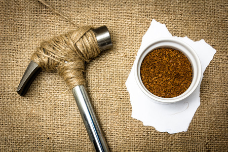 A hammer stopped from destroying a pot full of coffeeの写真素材