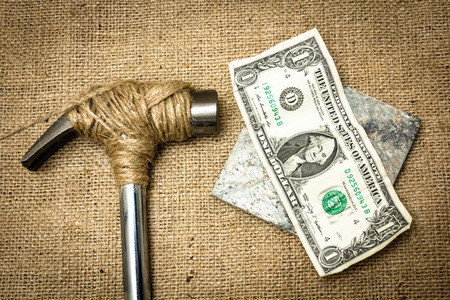 A hammer stopped from destroying moneyの写真素材