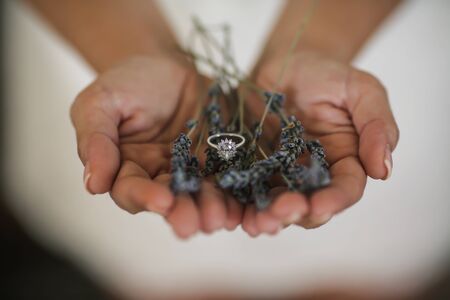 wedding bride is holding a diamond ring on a lavender plantの写真素材