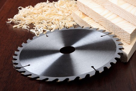 Circ saw blades, planks and shavings on dark backgroundの写真素材