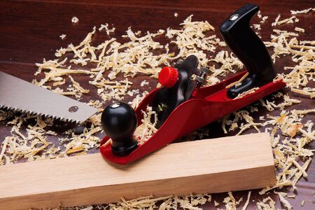 Red plane, wooden brick, handsaw and shavings