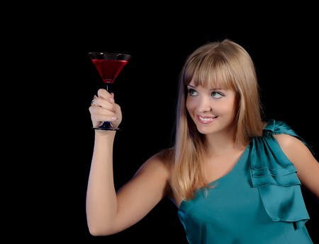 The young beautiful girl with a glass of a red drink.の写真素材