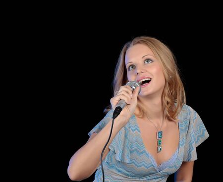 Portrait of the young beautiful girl singing in a microphone.の写真素材