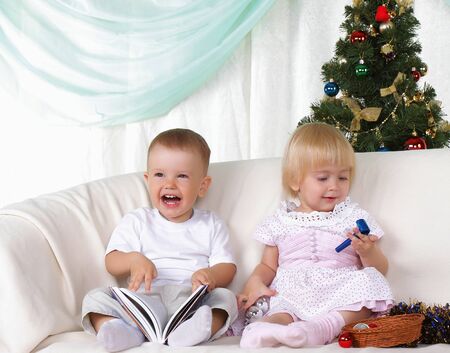 Kids playing near to christmas fur-tree の写真素材