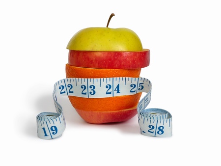 Slices of apples and orange as one fruit and a measuring tapeの写真素材