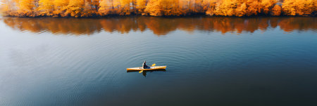 Aerial view of a man kayaking on a lake in autumnの素材