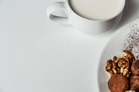 a delicious dessert of chocolate truffles and a cup of fresh milk, dried fruit truffles, healthy and very tastyの写真素材
