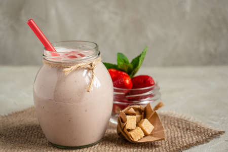 delicious and healthy strawberry milkshake in a jar, strawberries and cane sugar with a red heart of strawberry jamの写真素材