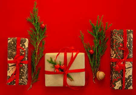 Christmas and New Year card, background - spruce, gifts on a red background, symmetry. Flat lay,...