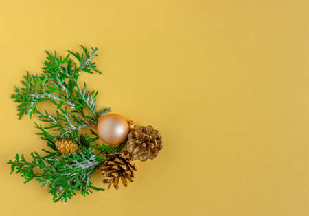 Christmas and New Year card, background - fir tree and cones on yellow-gold background. Flat lay, copy space, top viewの写真素材