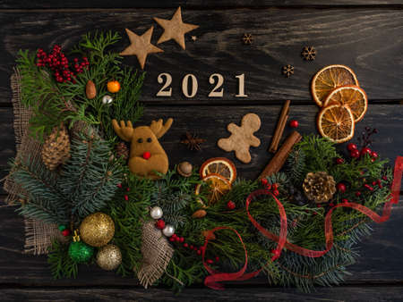 Atmospheric New Years composition 2021 on a wooden background, pine cones, tree, gingerbread cookies, gifts. Flat layの写真素材