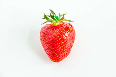 One bright strawberry on a white background, appetizing, beautiful, dietary. Place for text, copy space, flat layの写真素材