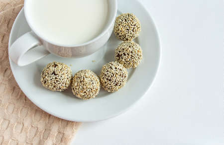 truffles with cocoa, coconut and sesame with chocolate and marshmallows and a cup of fresh milk, delicious dessertの写真素材