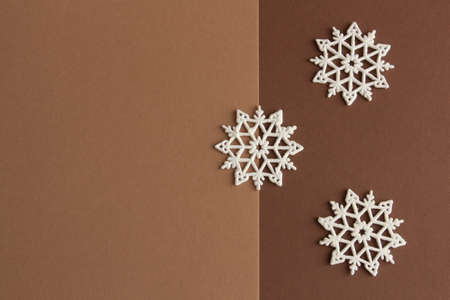 Stylish christmas composition, white snowflakes on a brown and beige background, copy space. High quality photoの写真素材