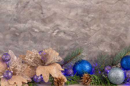 christmas composition in silver blue color, frame with blue garland and spruce branches on gray background, christmas balls and decorations, copy space. High quality photoの写真素材