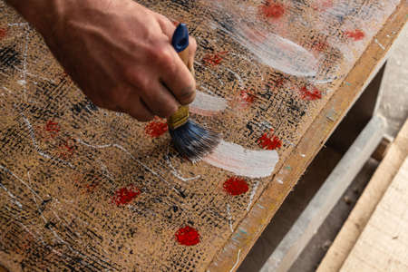the process of painting a photo background with colored paints on wood