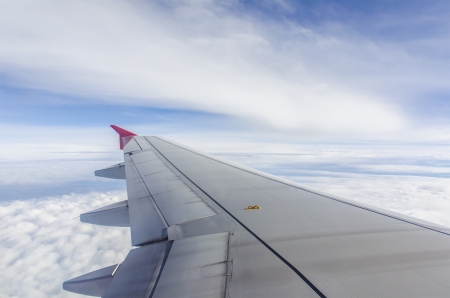 Wing of an airplane flying above the cloudsの写真素材