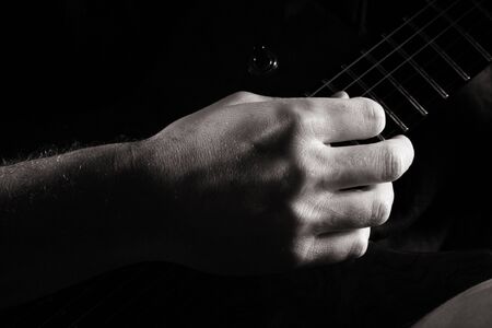 Fingerpicking on electric guitar; toned monochrome imageの写真素材