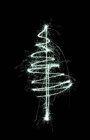christmas tree drawn in the air with a sparkler trail, on black backgroundの写真素材