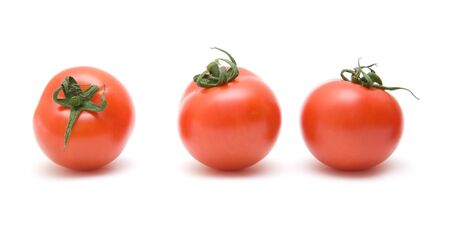 three ripe red tomatoes in a row; isolated on white backgroundの写真素材