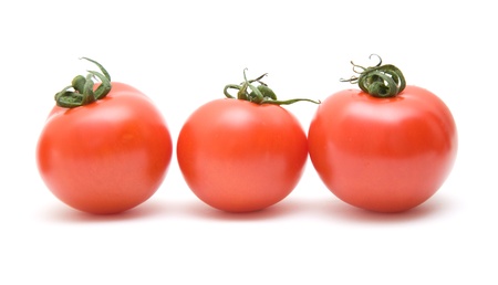 three ripe red tomatoes in a row, isolated on white backgroundの写真素材
